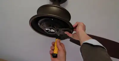 Electrician installing ceiling fan mounting bracket and fixture in Minneapolis, MN