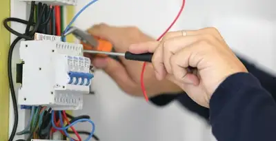 Electrician installing and adjusting circuit breakers in an electrical panel in Minneapolis, MN