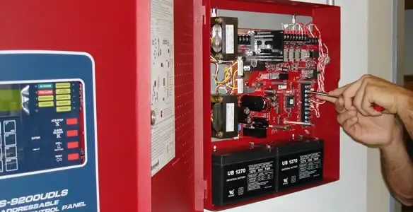 fire alarm installation service showing technician configuring fire alarm control panel in Minneapolis, MN