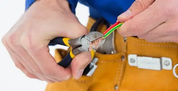 licensed electrician securing electrical wiring with professional tools during service work in Minneapolis, MN